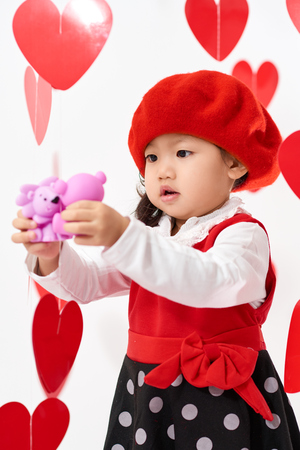 Cute Asian baby girl with hearts and rose pedals on Valentine's Dayの写真素材