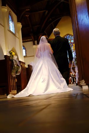A bride and her father beginning their walk down the aisle.の写真素材