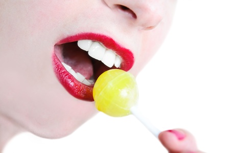 Girl's mouth with yellow lollipop isolatedの写真素材