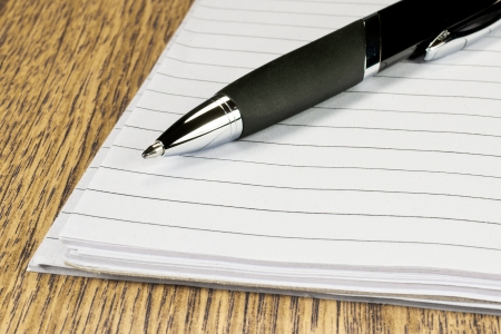 Pen and papers on wooden deskの写真素材