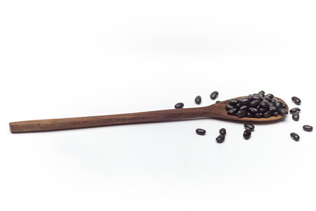 Wooden spoon with black beans, plant-based protein food, ideal for healthy cooking and natural food...