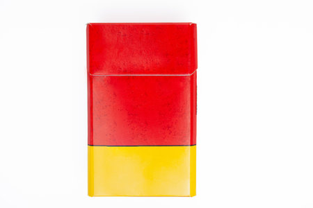 Red and yellow unbranded cigarette pack displaying addiction and tobacco conceptの写真素材