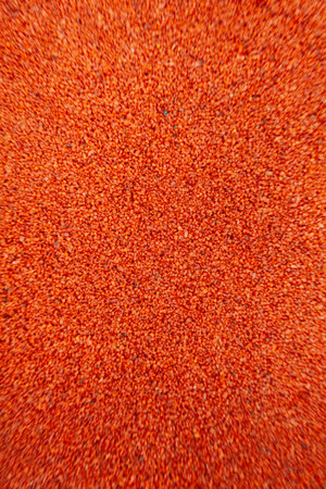 Macro top view of powdered colorant, highlighting fine texture, granules, and vibrant color with...