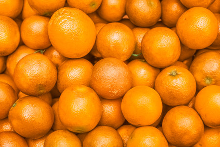 Horizontal full overhead shot of fresh oranges filling the frame. Textured peel and vivid tones....
