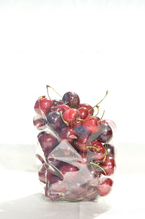a lot of cherrys in plastic bag isolated on white backgroundの写真素材