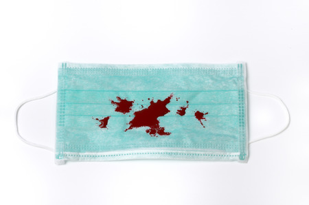 disposable face mask with blood on white backgroundの写真素材