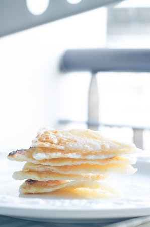 Six triangular roti dough stacked on white dish.の写真素材