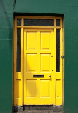 yellow door set in a frame of a green wallの写真素材