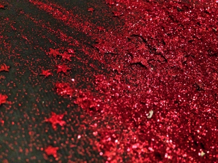 Red glitter and stars on black textured backgroundの素材
