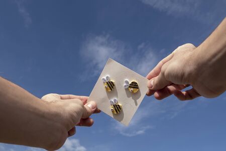 postal with bees in one hand