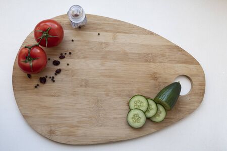 board with tomatoes and cut cucumber