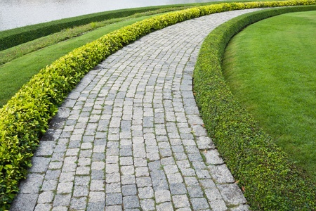 The Stone block walk path in the park with green grass backgroundの写真素材