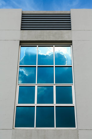 clouds with sun ray reflection on office window building