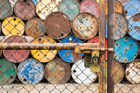 doors rusted iron fence locked for old tanks containing hazardous chemicalsの写真素材