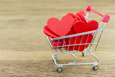 red heart shape in mini shopping cart on wooden rugged, concept of valentine dayの写真素材