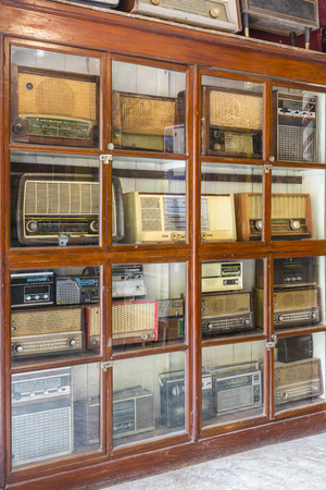 Ancient radios are placed in display cabinets inside antique show shopの写真素材