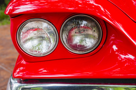 Close up headlight of a red vintage car