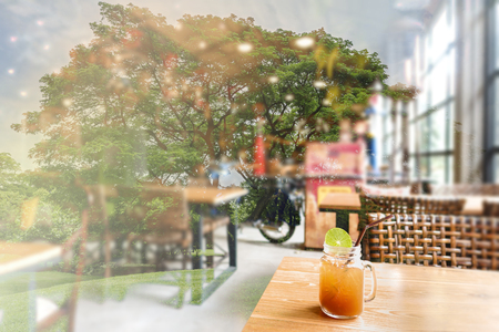Double exposure natural of cafe restaurant with ice lemon tea in mason jar on the wooden tableの写真素材