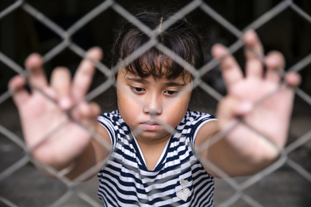 Single sad Asian girl child holding the cage was imprisoned make no freedom or lack of freedomの写真素材