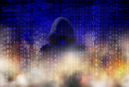 Murder hacker in black mask and hood is penetrating the domestic security information system with motion blur and fire, concept of defense and espionage of confidential informationの写真素材