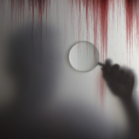 Shadow of special investigator holding a magnifying glass checking the blood stains of the victim...