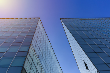 Close up of a modern architecture with cloud blue sky background - glass building exteriorの写真素材
