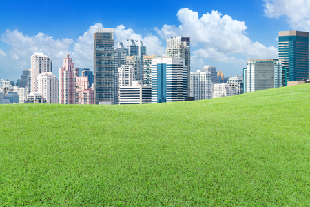 Green lawn outside the big city with cloud and blue skyのeditorial素材