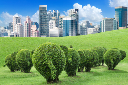 The tree is trimmed to the shape of elephants on green lawn outside the big city to add oxygen to the city, concept of save the earth and environment with environmental protection trapのeditorial素材