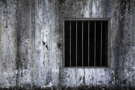 Window with rusty bars on old grungy prison cell wallの写真素材