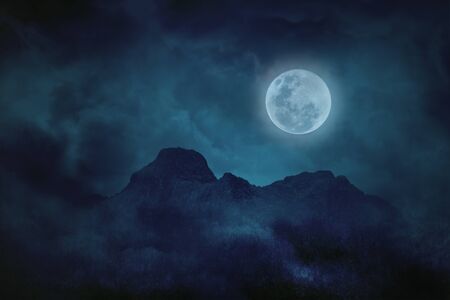 Blue full moon with mountains and forests in the darkness, Natural scary backgroundの写真素材