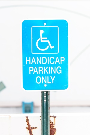 A bright blue handicapped parking sign showing wearの写真素材