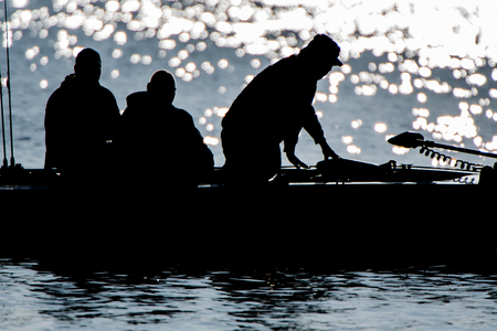 Silhouette of men in a fishing boat.の写真素材
