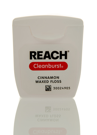 Winneconne, WI - 3 April 2016:  Container of Reach cleanburst cinnamon waxed dental floss on an isolated background.のeditorial素材