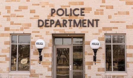 Shot of a police station with lights on both sides of the door that say police on them.のeditorial素材