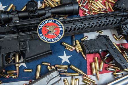Winneconne, WI - 15 March 2018: A NRA sticker with an AR-15, ammunition and hand pistols with an American Flag.のeditorial素材