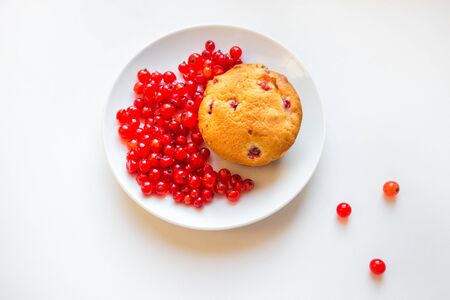Cupcake with red berries on a plate on a white background. Top view.の写真素材