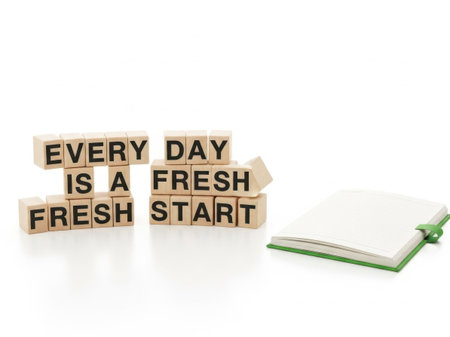 The image features a collection of wooden blocks arranged on a white surface, each block bearing a letter to form the inspirational quote 'EVERY DAY IS A FRESH START.' Adjacent to the blocks, there is a green notepad and a pen, suggesting a setting of planning or note-taking. The overall scene evokes a sense of positivity and motivation, encouraging the viewer to embrace new beginnings each day.の素材