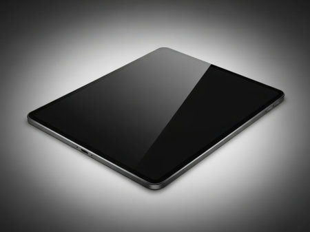 The image showcases a sleek, modern tablet with a reflective screen, positioned at an angle against a dark background. The tablet has a smooth, metallic edge and a glossy finish that reflects light, creating a striking visual effect. The screen displays a gradient of black and dark gray, adding to the overall minimalist aesthetic. The design is streamlined, emphasizing portability and elegance, making it an ideal device for both work and entertainment.の素材