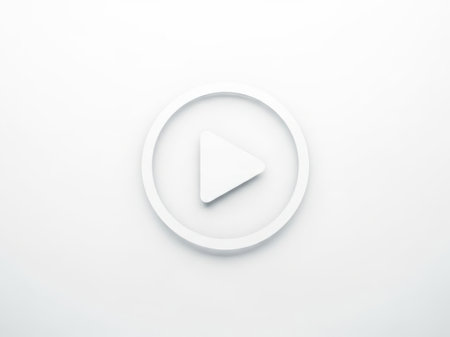 The image features a minimalist design with a prominent play button symbol centered against a plain, light-colored background. The play button is depicted in a simple, clean style with a white color that contrasts subtly with the background. The overall aesthetic is modern and uncluttered, emphasizing the play button as the focal point.の素材