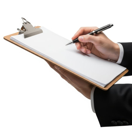 The image depicts a business professional, dressed in a suit, signing a document on a clipboard. The individual holds a pen in their right hand, poised to sign the paper. The clipboard is metallic with a secure clasp, ensuring the document remains in place. The background is plain white, putting the focus entirely on the action of signing the document. This scene suggests a formal or official setting, possibly related to business, legal, or administrative tasks.の素材