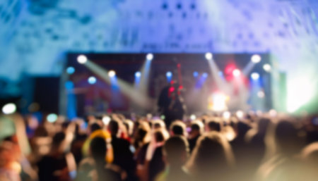 blurred concert crowd in front of bright stage lights - abstract photoの写真素材