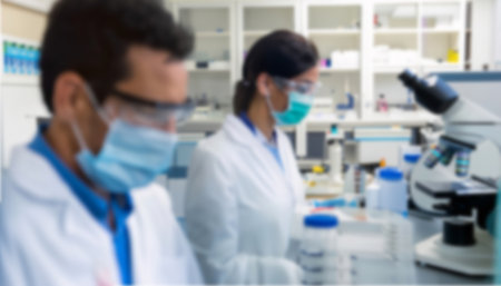 Blurred image of scientists working with microscope in laboratory. Scientific research and development concept.の写真素材
