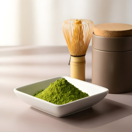 Green matcha tea powder in bowl with bamboo whisk and brush on tableの素材