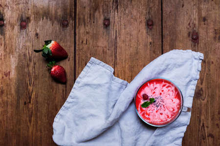 Fresh strawberry smoothie decorated with flower drawing line by mixed strawberry and yogurt smoothie. On wooden table with copy space.の写真素材