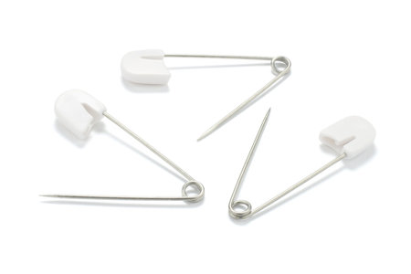 Safety pins on white background with shadowの写真素材