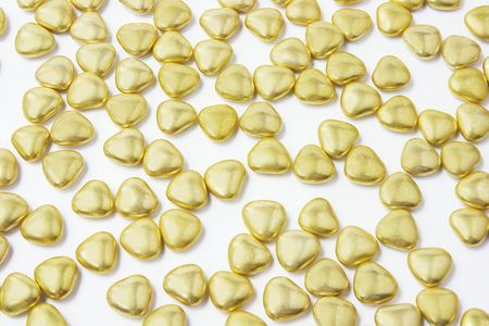 Heart-shaped Gold Chocolate Lollies on White Backgroundの写真素材