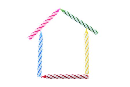 Birthday Candles Arranged in Shape of House on White Backgroundの写真素材