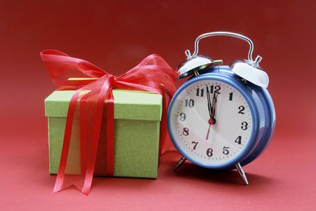Alarm Clock and Gift Box on Red Background