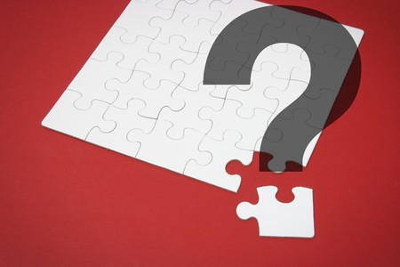 Jigsaw Puzzle and Question Mark on Red Backgroundの写真素材