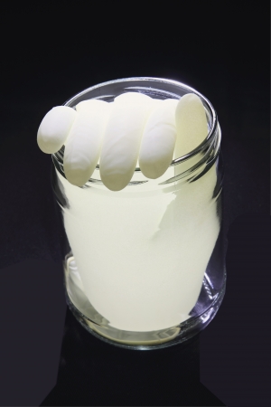 Rubber Glove with Water in Jar on Black Background